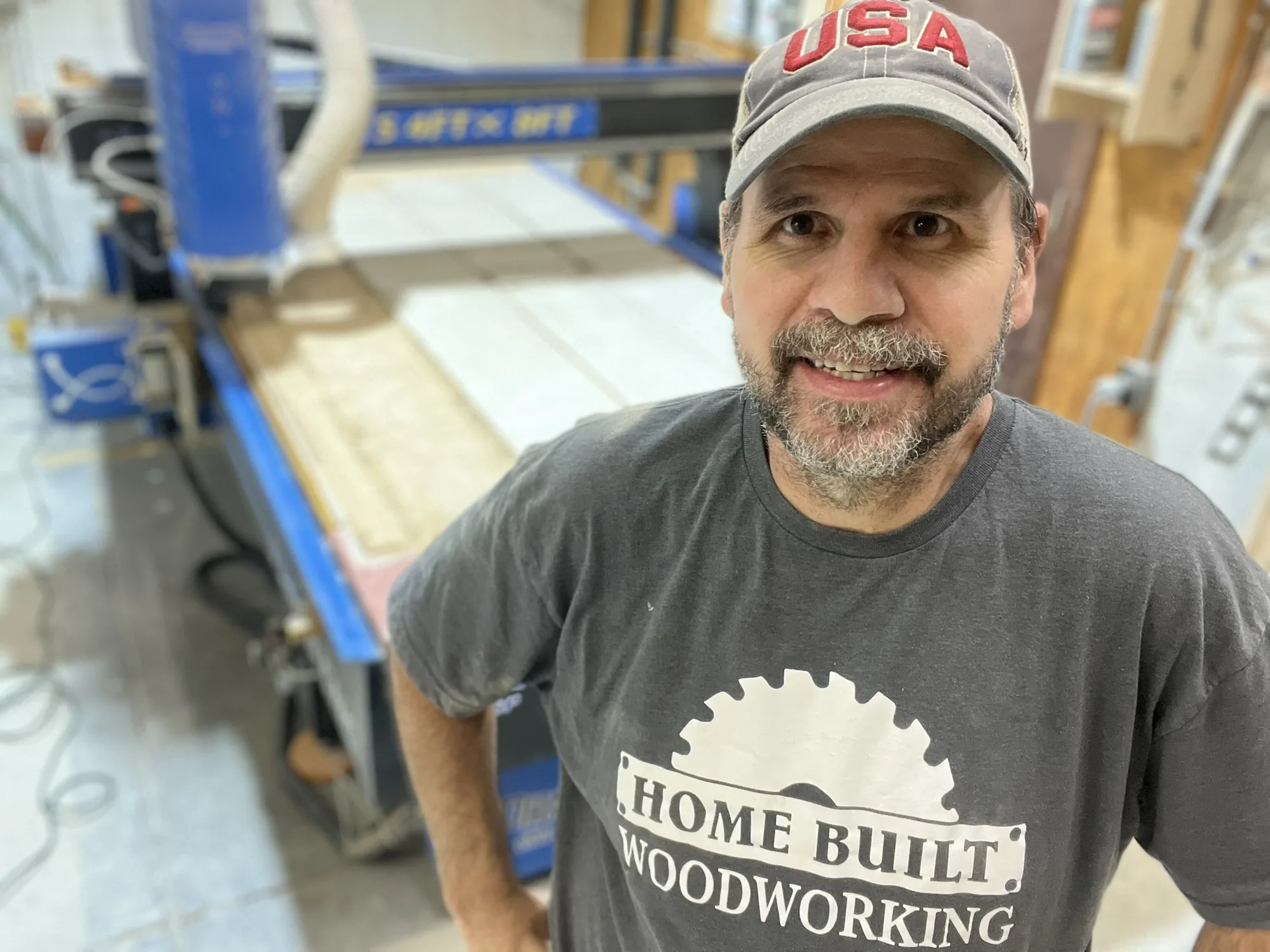 Chad in the Home Built Woodworking shop beside cabinetry in progress
