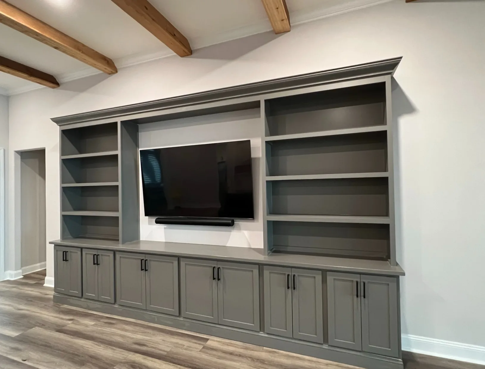 Grey built-in media wall with cabinet storage and open shelving