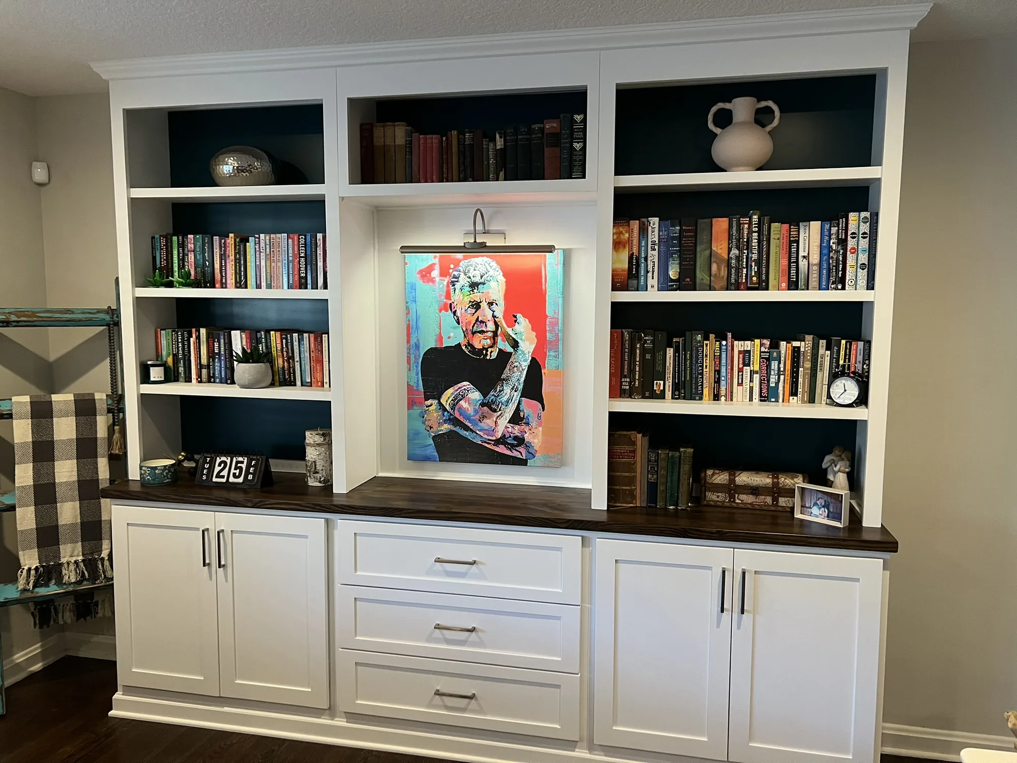 White library built-in with dark shelf backs and wood counter